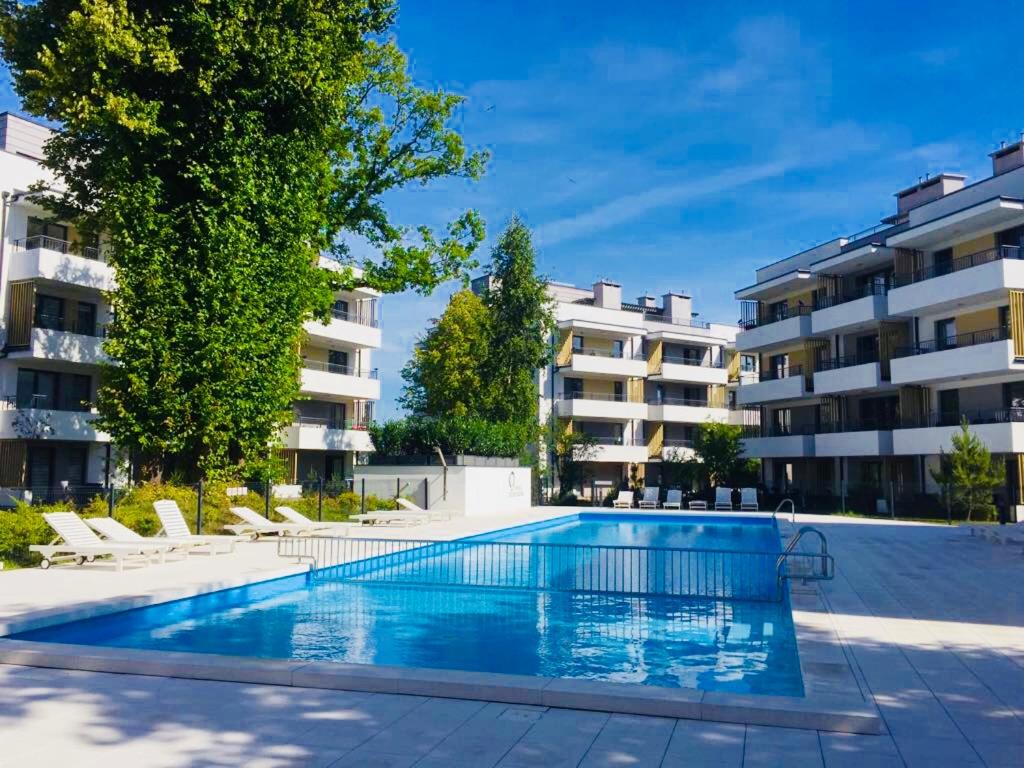 una piscina frente a un edificio de apartamentos en Apartament Amber Baltic - Rezydencja Ustronie Morskie, en Ustronie Morskie