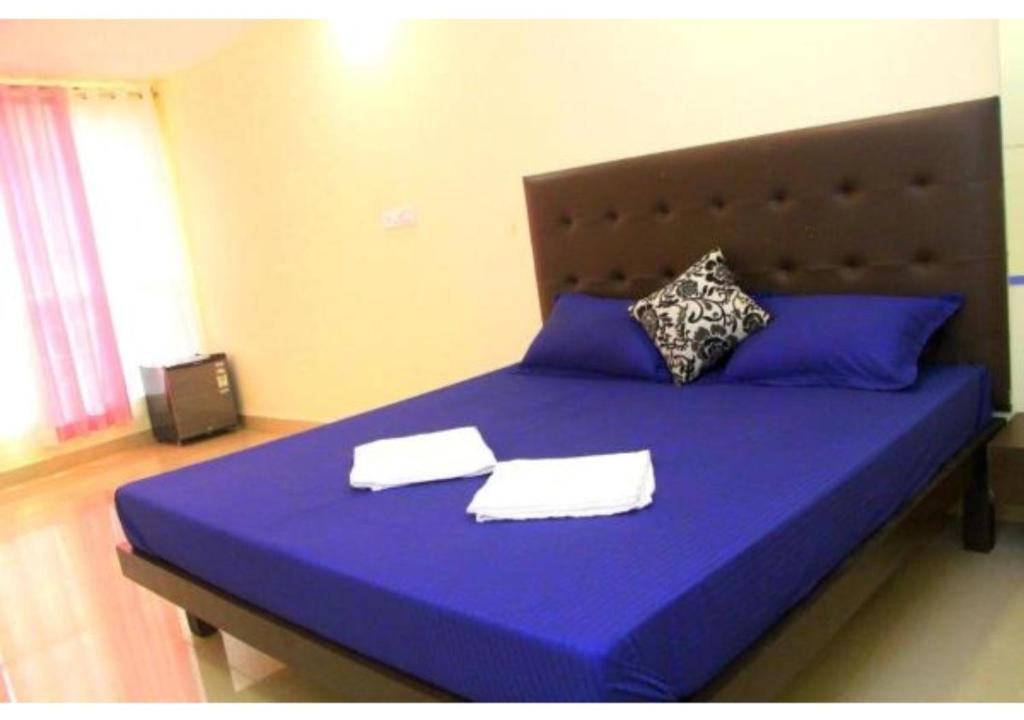 a blue bed with two white towels on it at Deluxe Room near Calangute Mall in Calangute