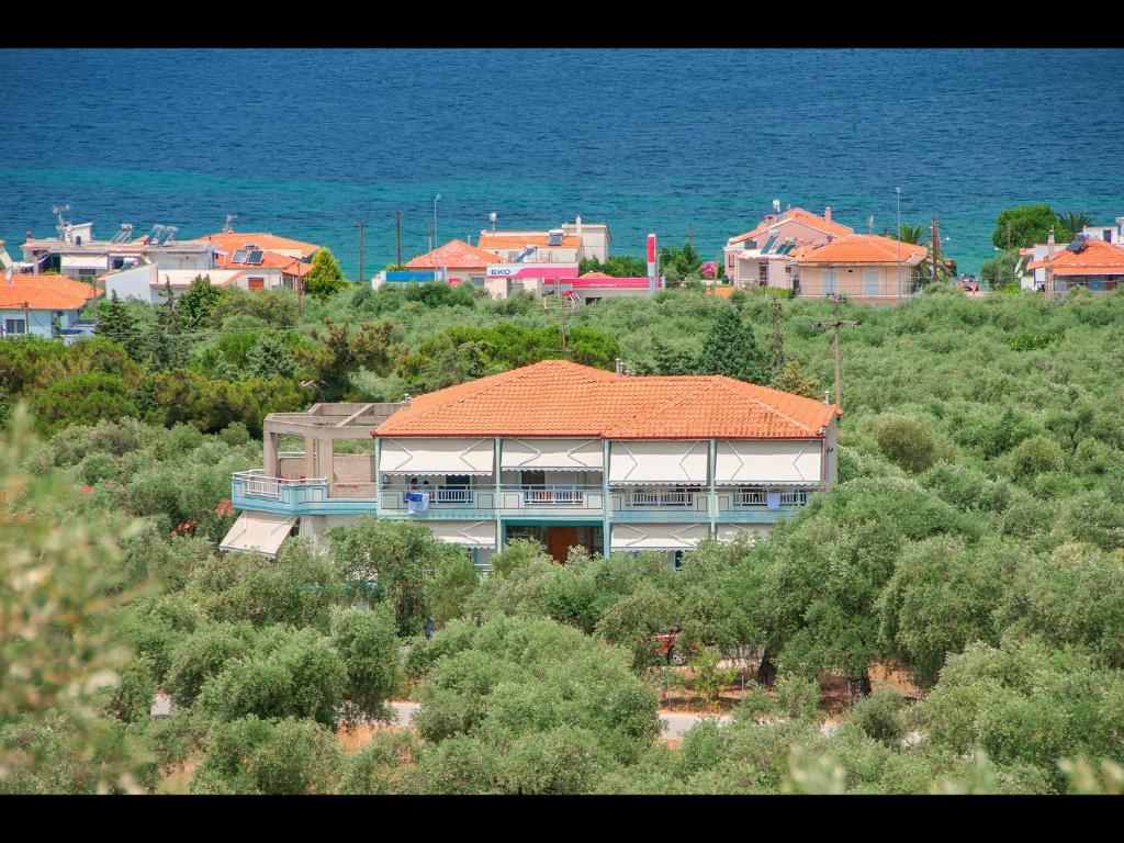 ein Gebäude mit einem orangenen Dach auf einem Hügel in der Unterkunft Panagiotis Hotel in Skala Sotiros