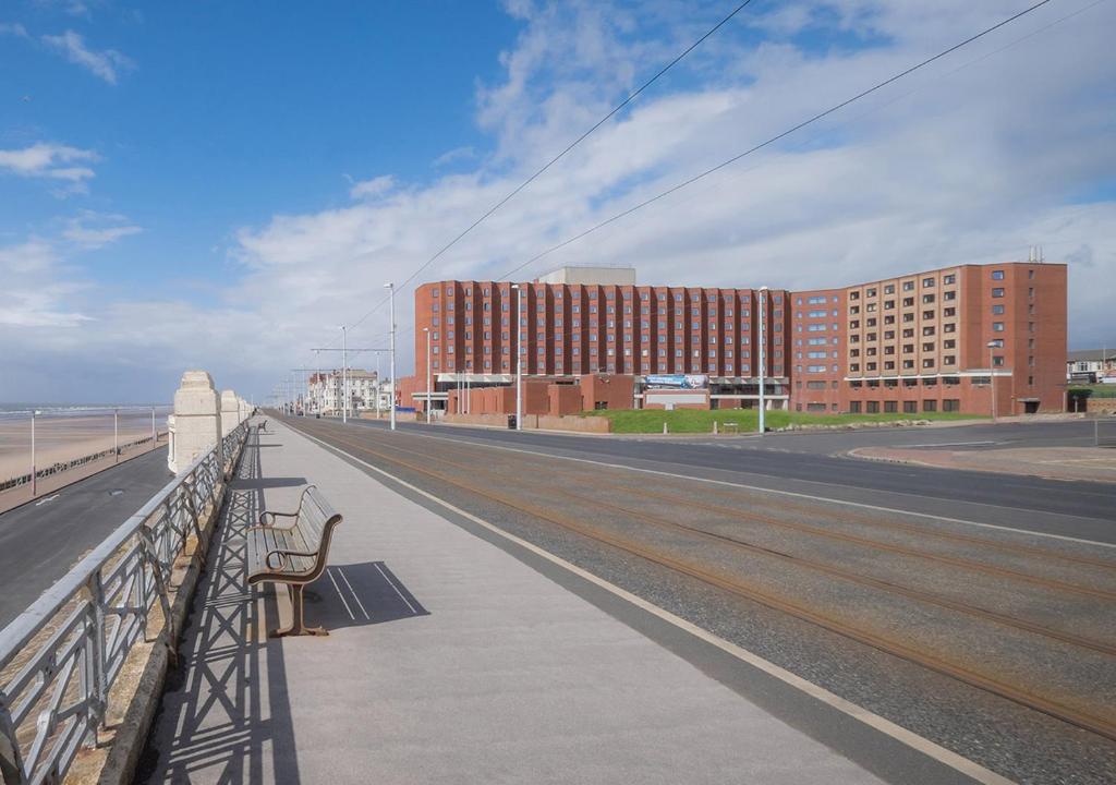 a bridge with benches and a building on the beach at Grand Hotel Blackpool in Blackpool