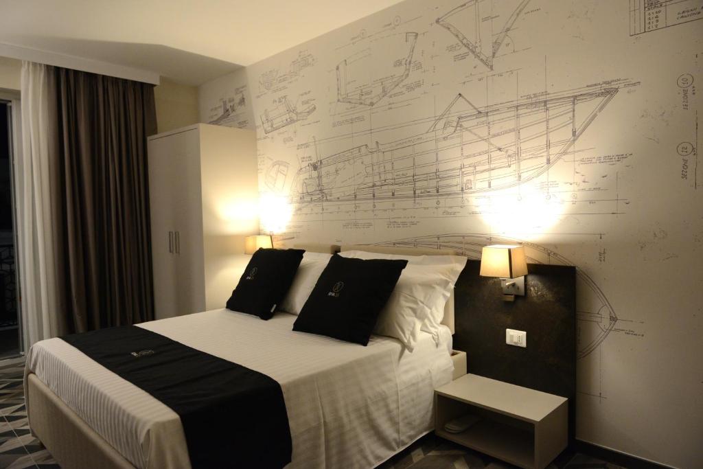 1 dormitorio con 1 cama con dibujos en la pared en Riva 33, en Porto Cesareo
