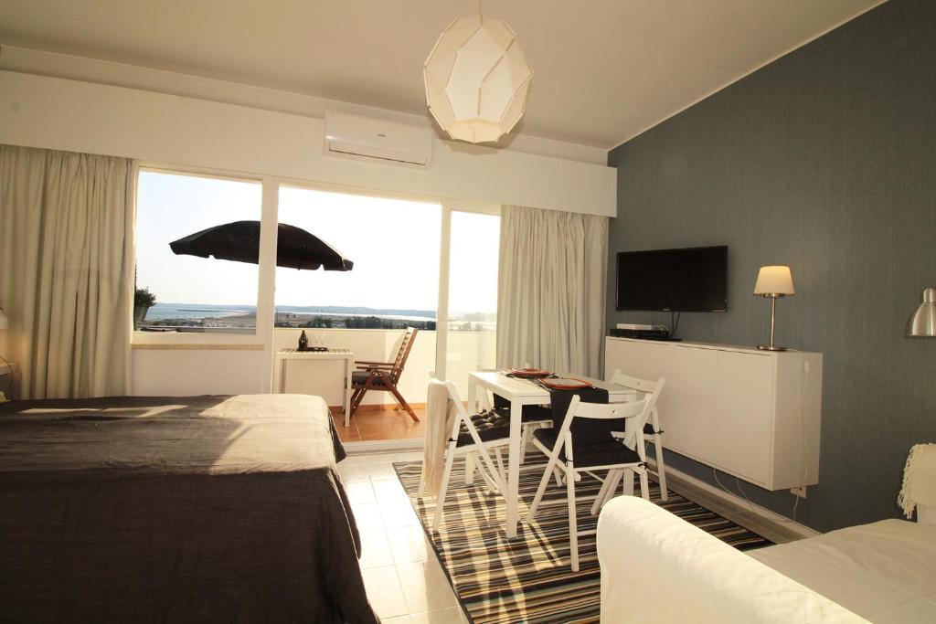 a hotel room with a bed and a table with a view at Torralta Alvor Beach 601 in Alvor