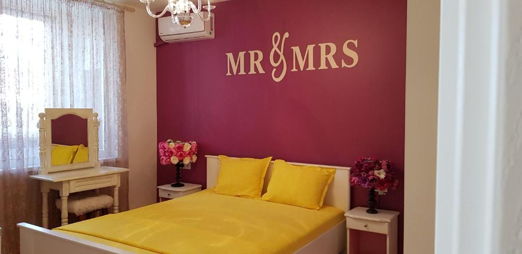 ブルガスにあるFlorata apartmentのベッドルーム1室(紫の壁の黄色いベッド1台付)