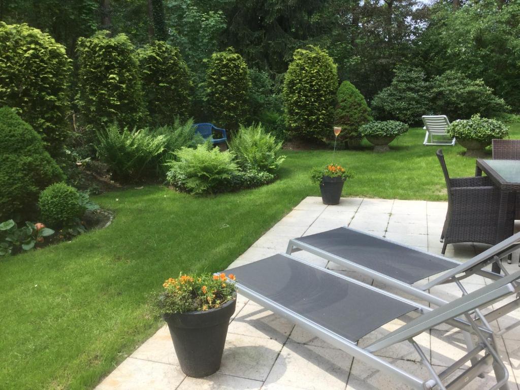 eine Terrasse mit einem Tisch und Stühlen im Garten in der Unterkunft FeWo im Grünen mit Terrasse und Garten - gratis Therme in Bad Bevensen
