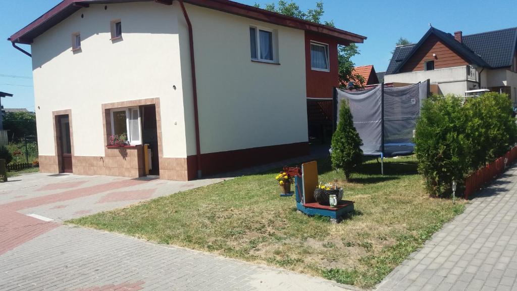 una casa blanca con un patio delante en Apartament Małgosia, en Swarzewo