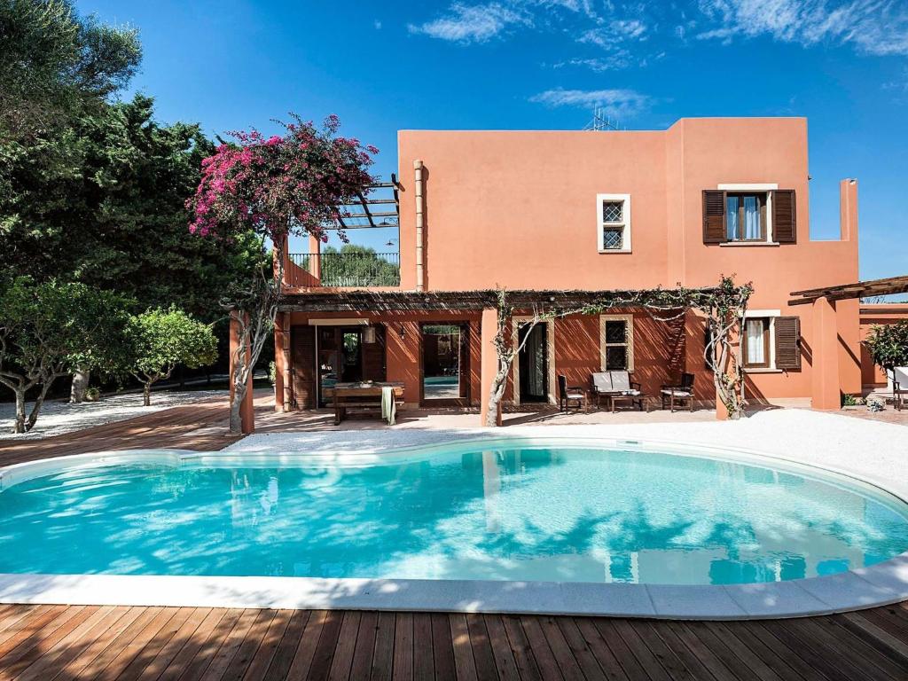 a swimming pool in front of a house at Belvilla by OYO Villa Arangea Dieci in Marsala