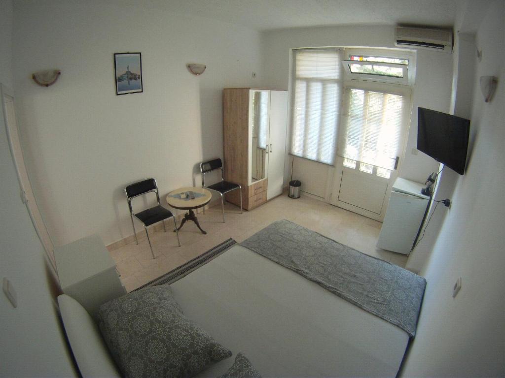 a small living room with a table and a refrigerator at Salona suite in Solin