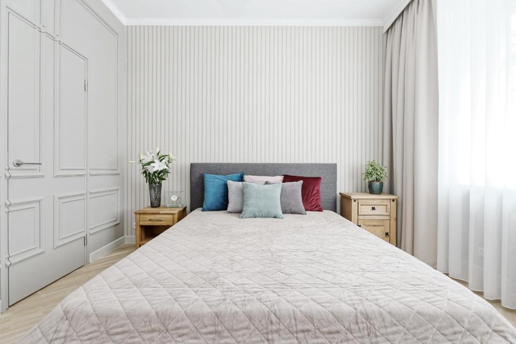 Un dormitorio con una cama grande con almohadas de colores. en Ausekla Deluxe Apartment, en Riga