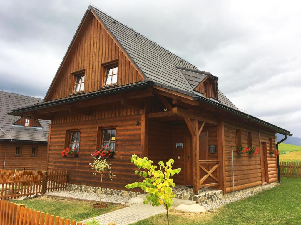 eine große Holzhütte mit schwarzem Dach in der Unterkunft Chalupa na Liptove - Chata pri Mare in Liptovský Trnovec