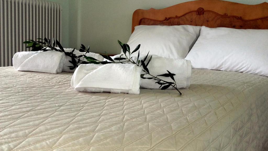 a bed with white pillows and plants on it at Deskas House. Two Floor Apartment With Excellent View in Parga