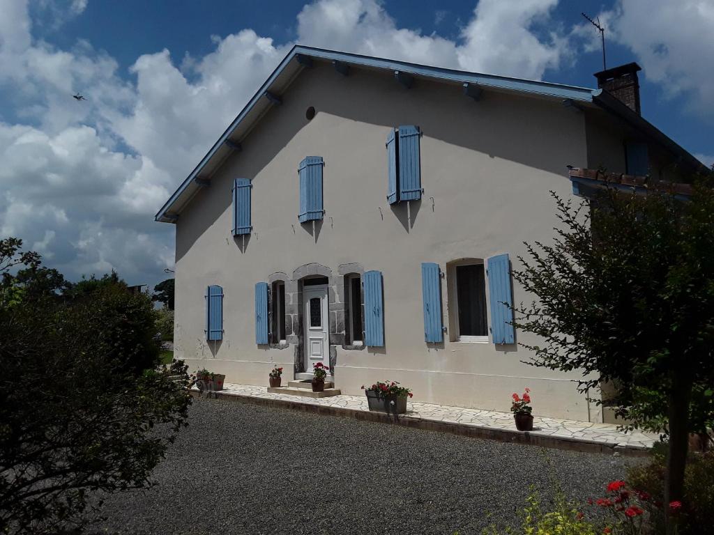ClermontにあるGîte de Marcadéの青いシャッターが付いた白い家