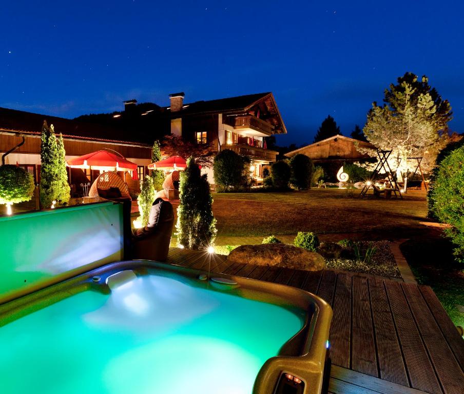 uma piscina em frente a uma casa à noite em Das Landhaus em Pfronten