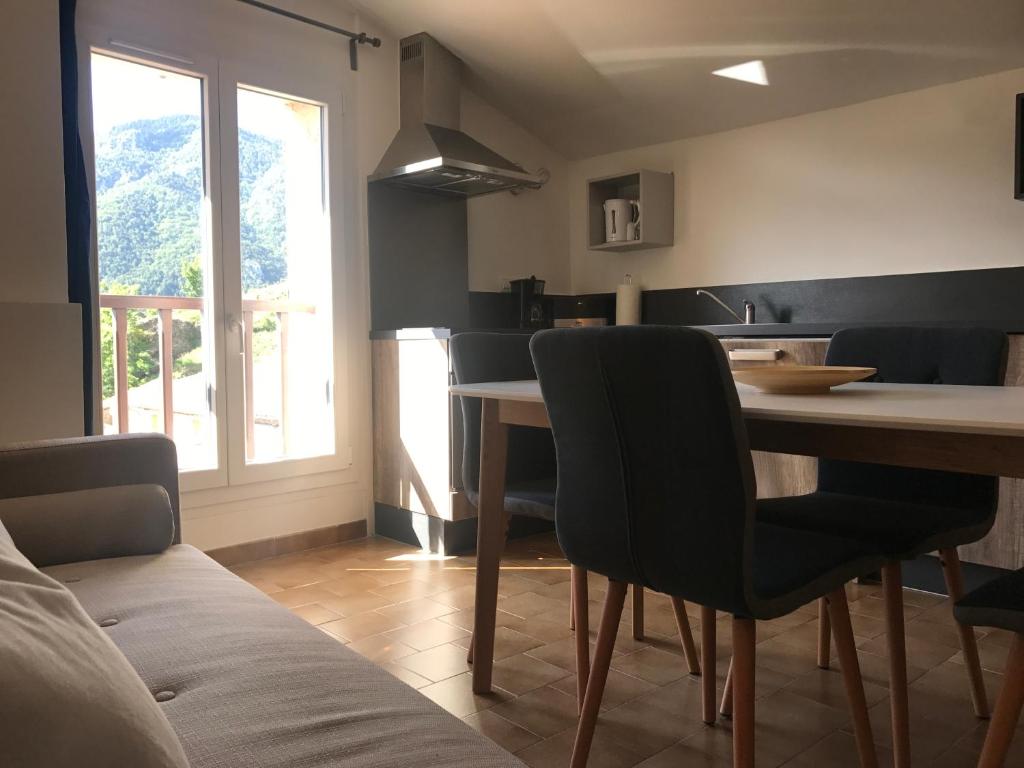 een keuken met een tafel en stoelen in een kamer bij Lavande 3ème étage in Le Mas