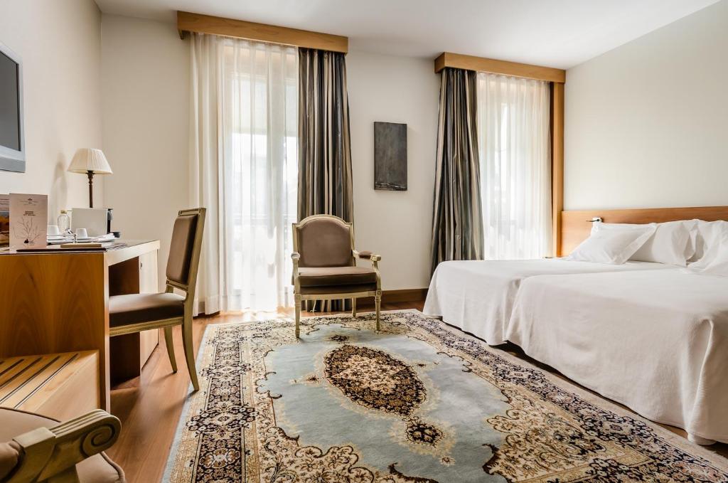Postel nebo postele na pokoji v ubytování Gran Hotel La Perla