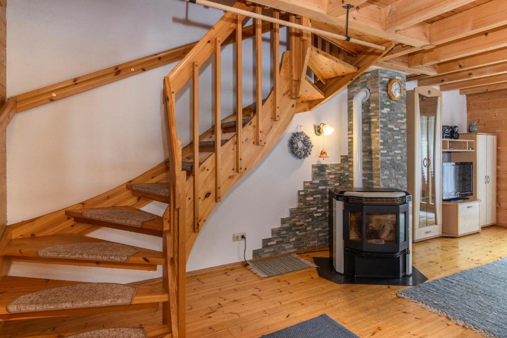 a wooden staircase in a living room with a fireplace at Haus Monika Silvrettablick in Sankt Gallenkirch