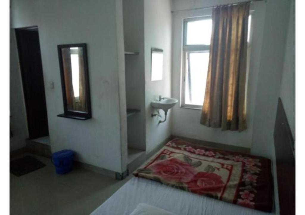 uma casa de banho com um lavatório, uma janela e um tapete em Budget Hotel near Bus Stand em Udaipur