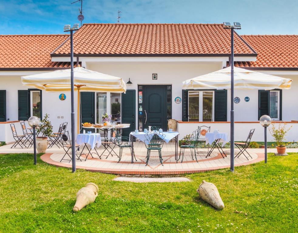 a house with a patio with a table and chairs at Villa Maredona in Ascea
