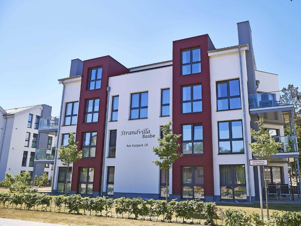 un immeuble d'appartements avec un panneau sur son côté dans l'établissement Strandvilla Baabe F 635 WG 11 "Bernstein" mit Meerblick, Kamin, Sauna, à Baabe