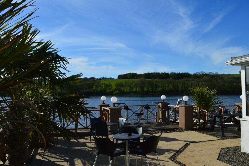 een patio met uitzicht op het water bij The Inn on the Loch in Castle Douglas