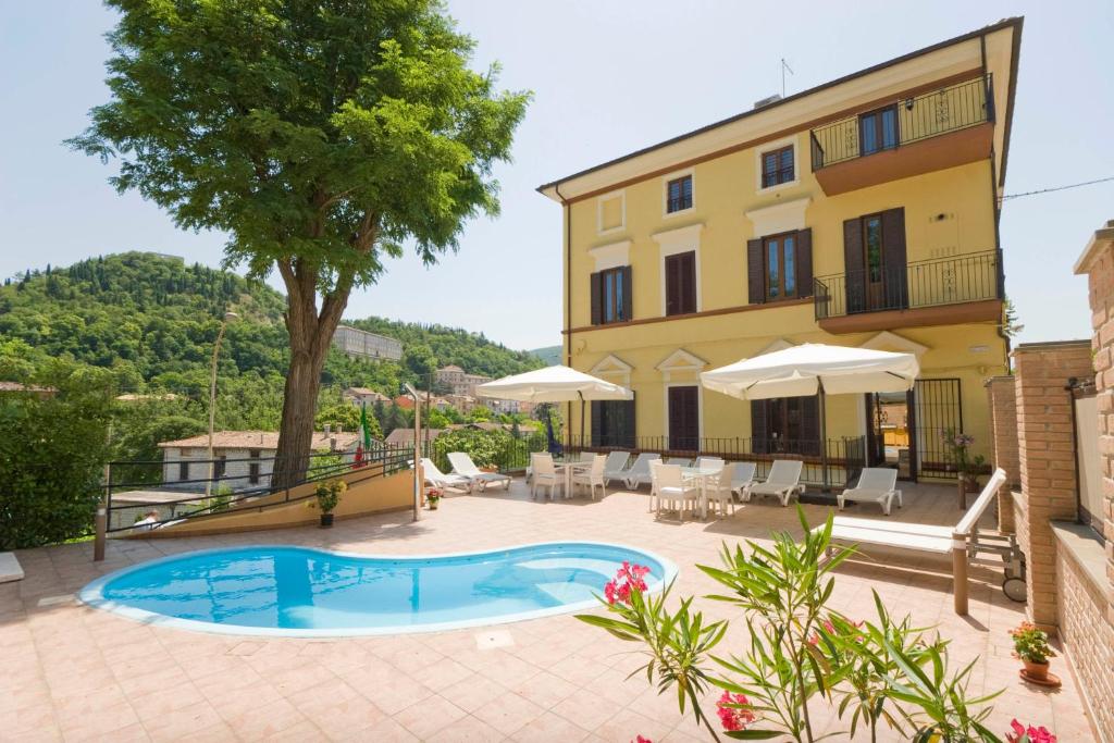 a courtyard with a swimming pool and a building at Raffaello Residence in Sassoferrato