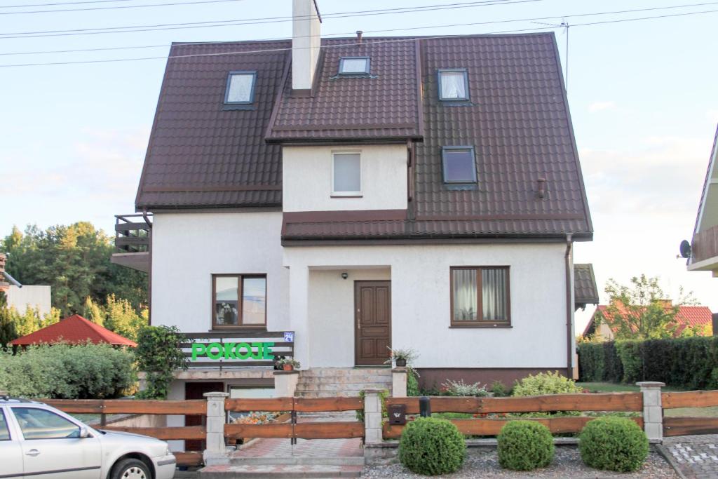 Casa blanca con techo marrón en Pokoje Gościnne U Basi, en Wilkasy