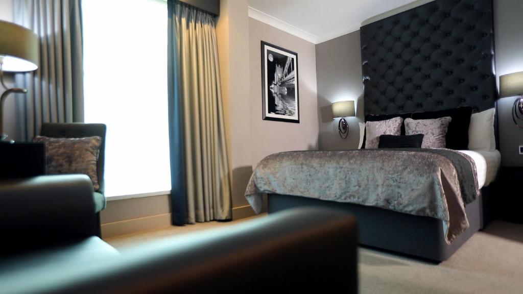 a hotel room with a bed and a window at The Continental Hotel, Heathrow in Hounslow