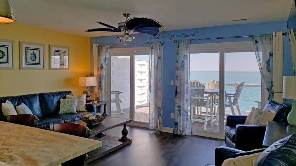 Put-in-Bay Waterfront Condo #207 في بوت-إن-باي: غرفة معيشة مع أريكة وإطلالة على المحيط