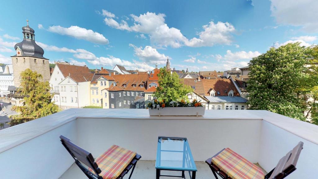 a balcony with two chairs and a view of a city at Hotel Goldene Traube in Coburg