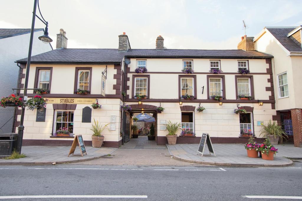 ein großes weißes Gebäude mit Schildern davor in der Unterkunft The Royal Oak Pub in Lampeter