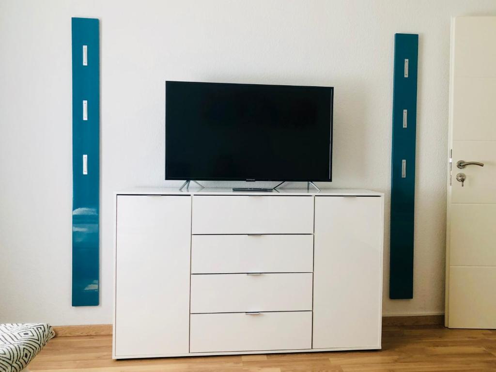 a white dresser with a television on top of it at KriDa Comfort Ferienwohnung in Garbsen