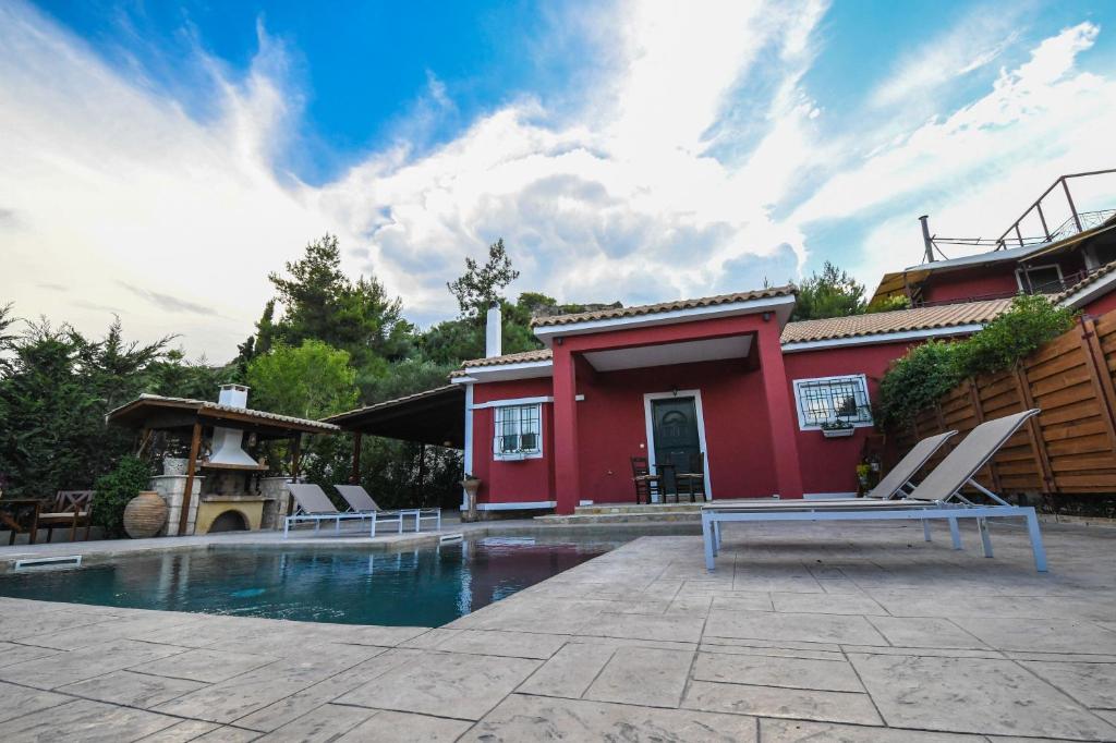 a house with a swimming pool next to a red house at Ktima Kallitero Villas in Argassi