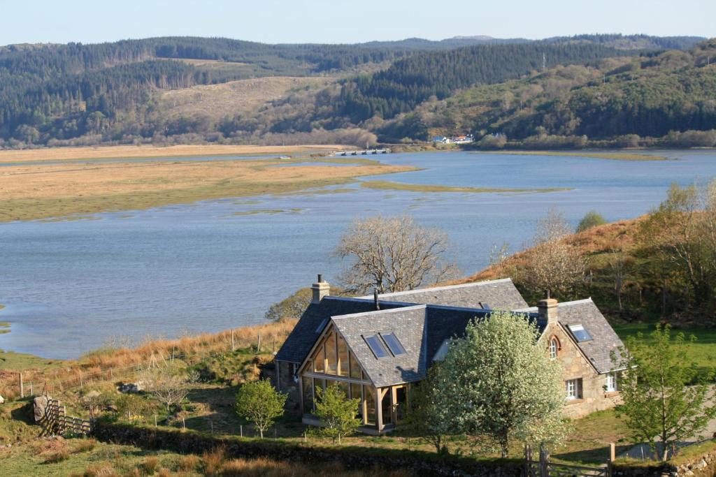 una casa en una colina junto a un cuerpo de agua en Winterton, en Lochgilphead