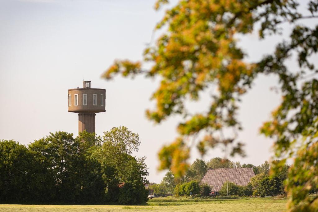 een watertoren in het midden van een veld bij Watertorenhotel Nes in Nes