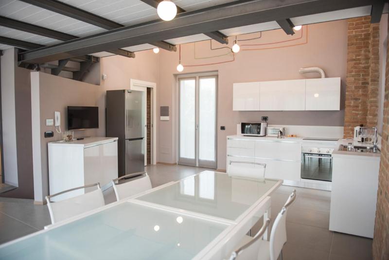 uma grande cozinha com electrodomésticos brancos e armários brancos em Cascina Goretta Agriturismo em La Morra