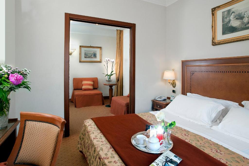 a hotel room with a bed and a table at Pinewood Hotel Rome in Rome