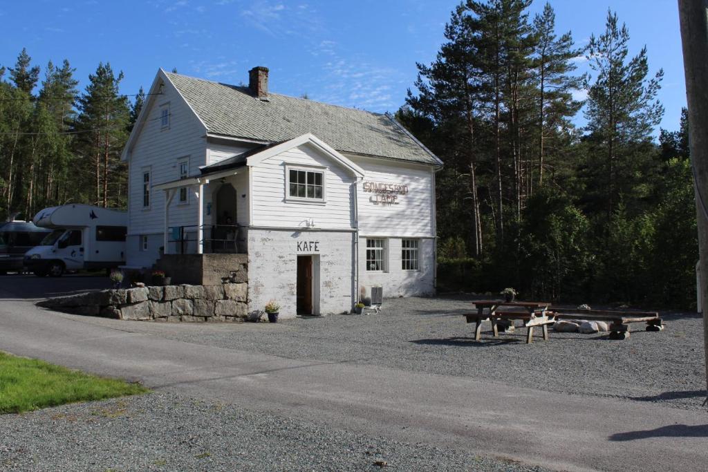 a white house with a picnic table in front of it at Songesand Camp in Songesand