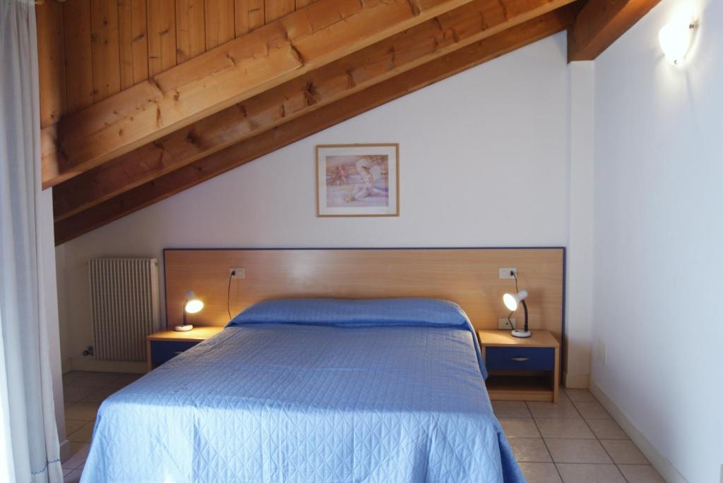 a bedroom with a blue bed and two night stands at Appartamenti Villa Paola-Pochi passi dal mare-Zona piazza Aurora-Lido di Jesolo in Lido di Jesolo