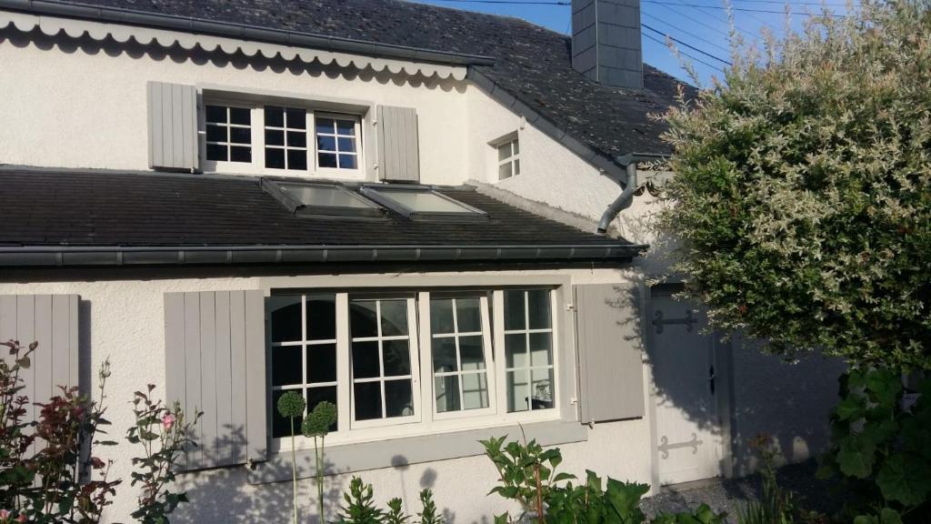 フロロンヴィルにあるLe Memagneの窓と屋根のある白い家
