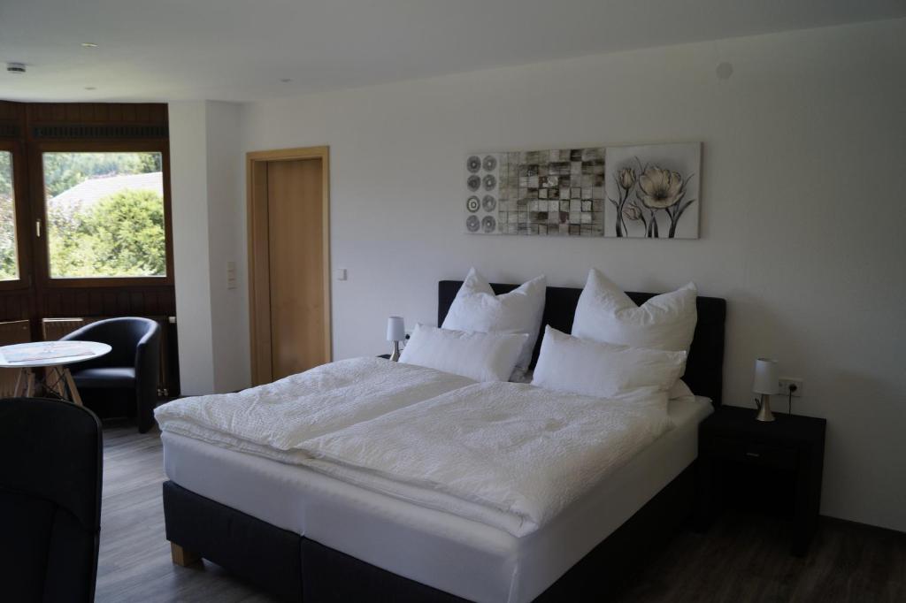 a bedroom with a large bed with white sheets and pillows at Am Irrenbächle in Albstadt