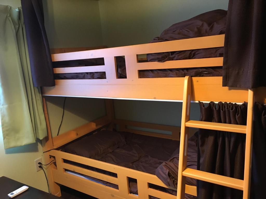two bunk beds in a small room with at Guest house AmaMin in Amami