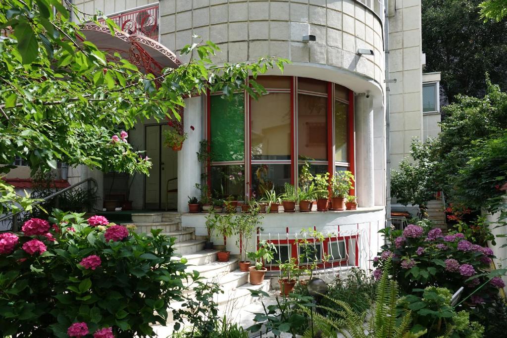 uma casa com vasos de plantas na frente dela em Vila A&B em Bucareste