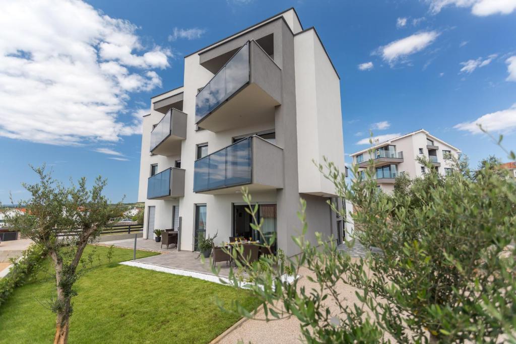 een huis met grote ramen en een tuin bij Apartment Elegance in Krk