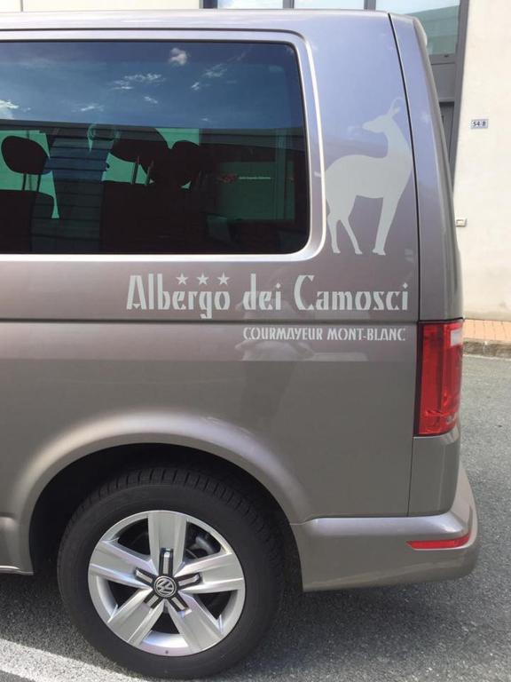 a grey truck with a sign on the side of it at Hotel Dei Camosci in Courmayeur