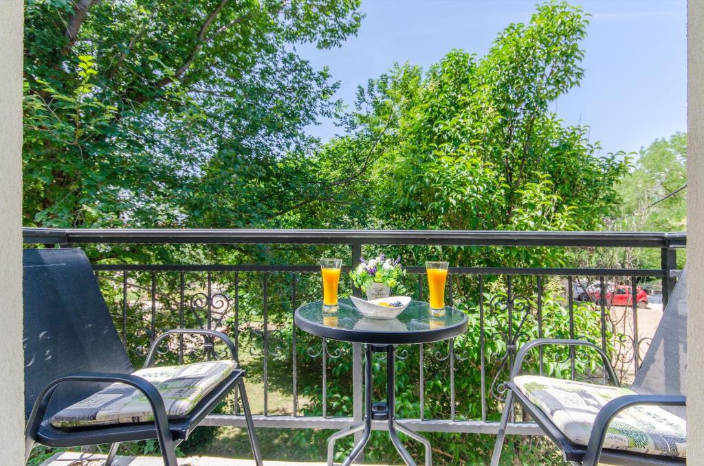 a table with two glasses of orange juice on a balcony at Beach & park Apartment in Kaštela