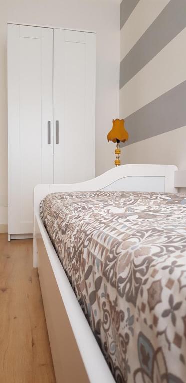 ミラッツォにあるCasa Vittoriaのベッドルーム1室(ブラウンと白の掛け布団付きのベッド1台付)