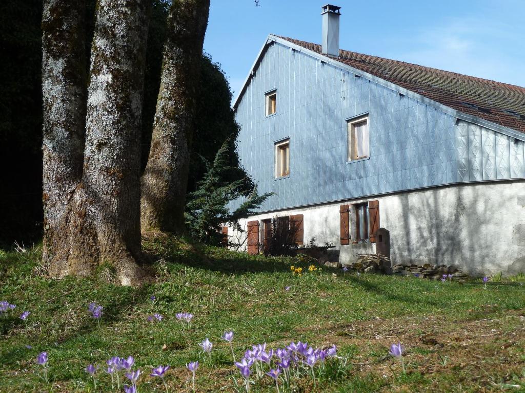 una casa con dos árboles y flores delante de ella en La Fritillaire, en La Montagne