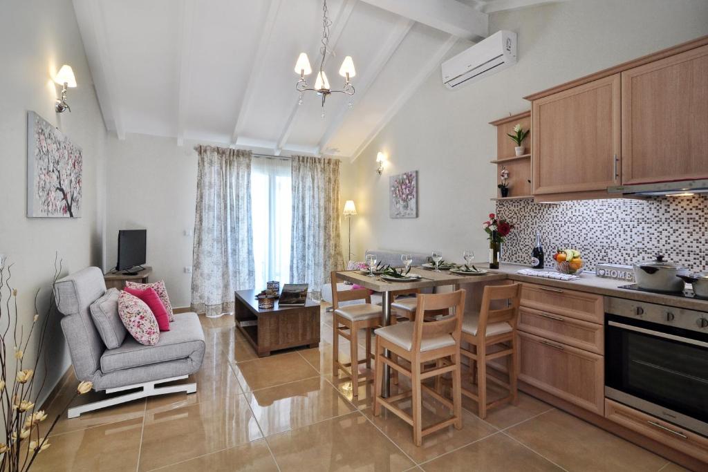 a kitchen with a table and chairs in a room at Mazis Apartments in Agios Gordios