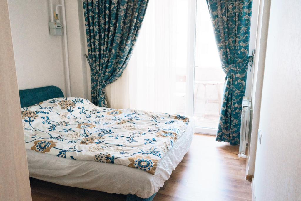 ノヴォロシースクにあるApartment at Engel'sa 79のベッドルーム1室(ベッド1台付)、窓(カーテン付)