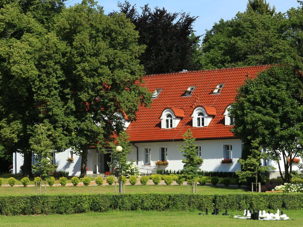 une grande maison blanche avec un toit orange dans l'établissement Stary Młyn Strzeszyn - Soft All Inclusive, à Łubowo