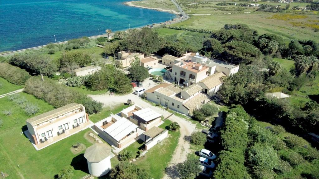 - une vue aérienne sur une grande maison avec l'eau dans l'établissement Azienda Agrituristica Tenuta Pizzolungo, à Erice